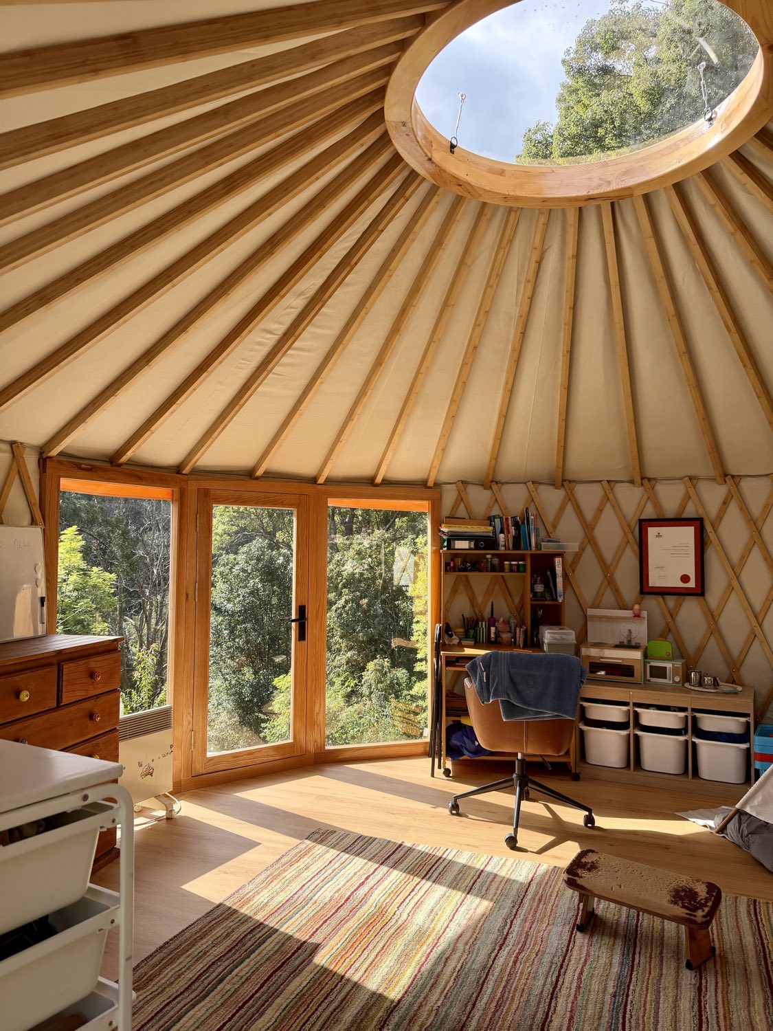Light-filled yurt interior looking up at the compression ring skylight