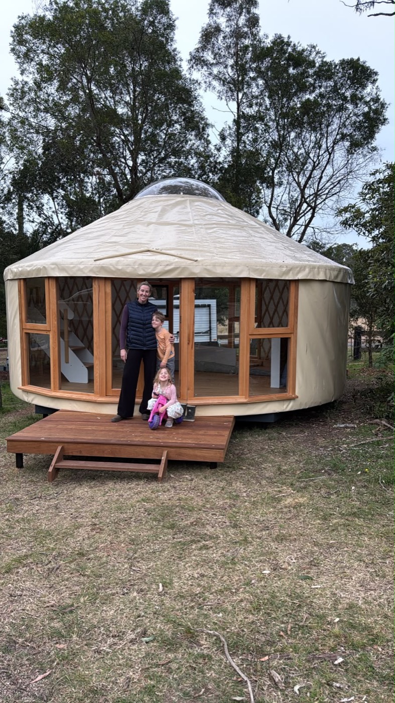 Jana and her kids on the deck of their new 6m yurt at the farm