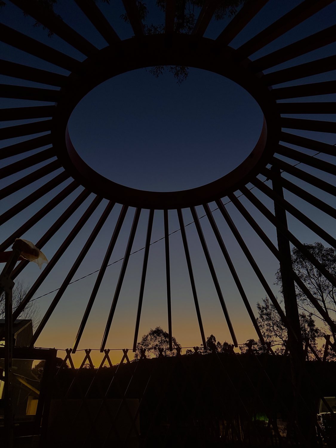 The compression ring and rafters in silhouette against a dusk sky